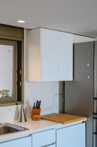 a kitchen with white cabinets and a sink at 5 meters from the beach in Chrani