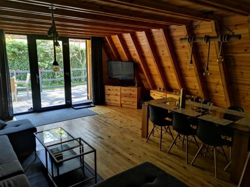 a living room with a table and chairs in a cabin at Jodłowy Zakątek NEW in Niechorze