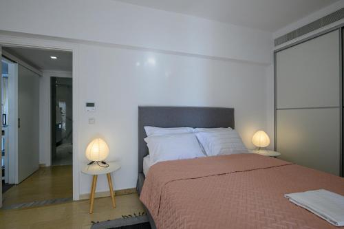 a bedroom with a large bed and two lamps at 5 meters from the beach in Chrani