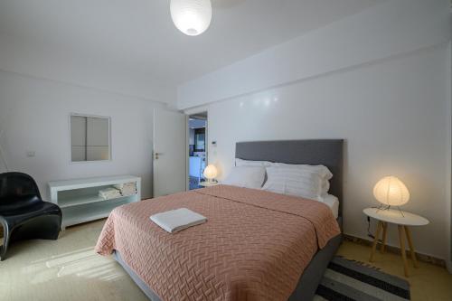 a bedroom with a bed and a chair and a lamp at 5 meters from the beach in Chrani