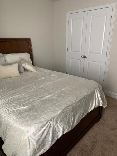 a bedroom with a bed with a white comforter at Private, quiet, immaculate bachelor pad with free parking on site in Decatur