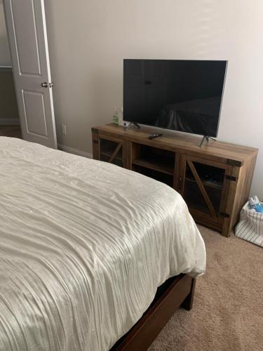 a bedroom with a bed and a flat screen tv at Private, quiet, immaculate bachelor pad with free parking on site in Decatur