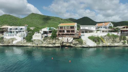 a group of houses on the side of a body of water at Lagun Ocean View Villa with Own Private Beach in Willemstad