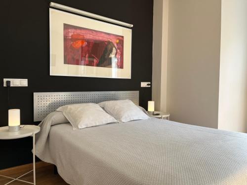 een slaapkamer met een bed met een zwarte muur bij Apartamentos León in León