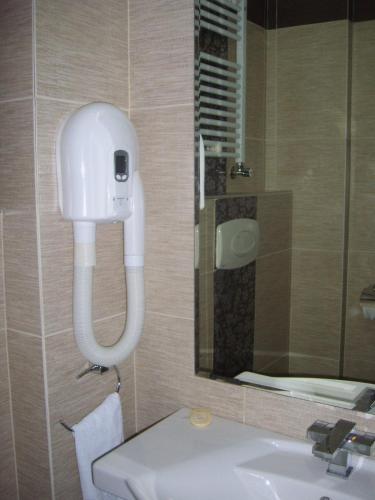 a bathroom with a sink and a phone on the wall at Hotel Sydney in Craiova