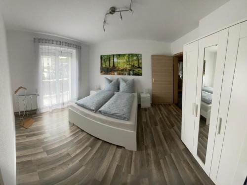 um quarto com uma cama e piso em madeira em Ferienwohnung Ziegenschweiz em Auerbach