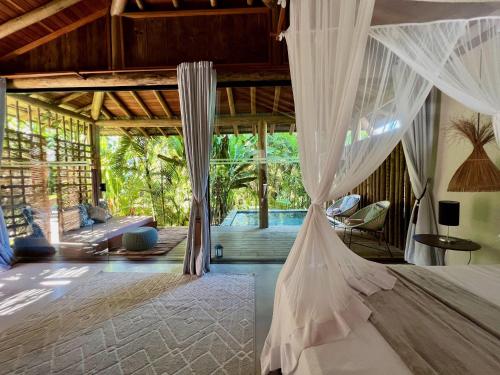 a bedroom with a bed with mosquito nets at Soleluna Casa Pousada in Trancoso