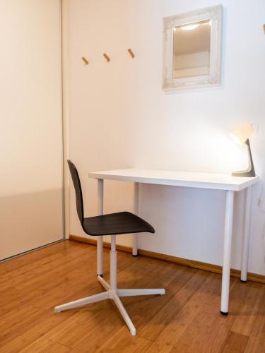 a white desk with a chair and a white table at D&N Apartment in Ljubljana
