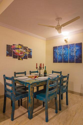 a dining room with a blue table and chairs at Villa Candolim in Candolim