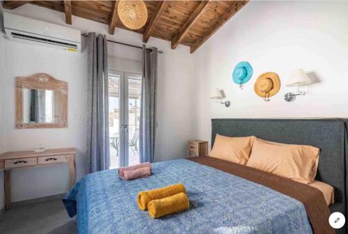 a bedroom with a blue bed with a yellow towel on it at Tertsa Casa Di Mare in Térsa