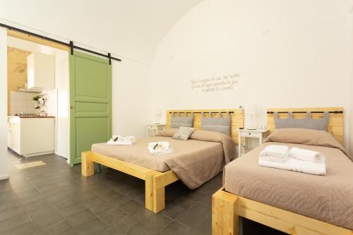 a room with two beds with towels on them at Pura Vida Barocca in Ragusa