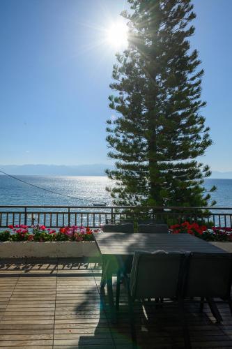 a table and chairs in front of a pine tree at 5 meters from the beach in Chrani
