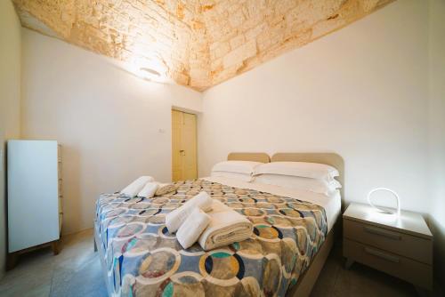 1 dormitorio con 1 cama con toallas en Domus Lapis - con TERRAZZA PANORAMICA, en Ostuni