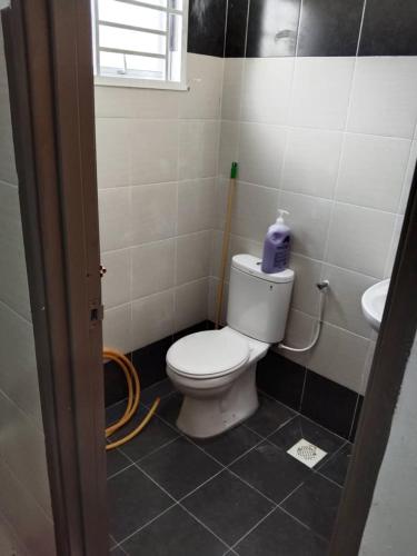 a bathroom with a white toilet and a sink at Abah StayCation in Sungai Besar