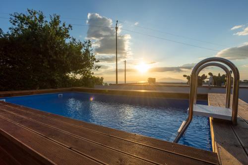 a swimming pool with a bench next to a wooden deck at Villa Aurora Pool & Fitness in Anacapri