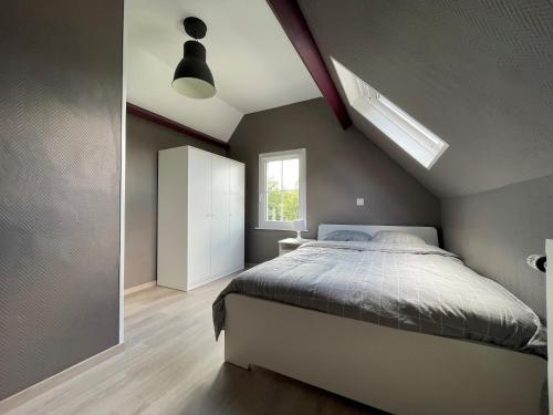 sypialnia z dużym łóżkiem i oknem w obiekcie Gite Au Chant d'Eole w mieście Ebly