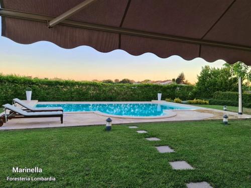 Cornale的住宿－馬里內拉住宿加早餐旅館，庭院内带长凳的游泳池