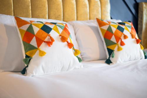 a white bed with two pillows on top of it at Stylish 2BR Apartment in Morriston in Swansea