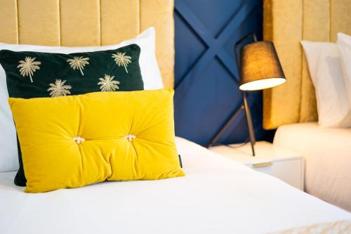 a yellow pillow sitting on top of a bed at Stylish 2BR Apartment in Morriston in Swansea