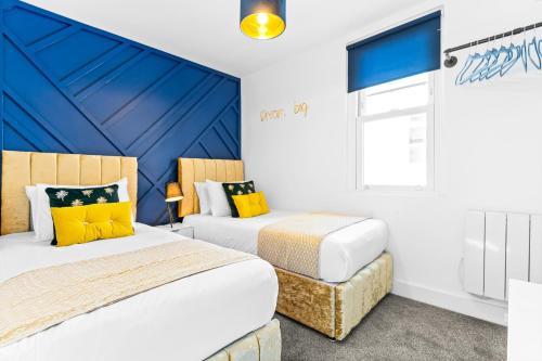 two beds in a room with blue and white at Stylish 2BR Apartment in Morriston in Swansea
