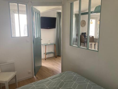 a bedroom with a bed and a mirror on the wall at Studio indépendant 30m2 4 pers chez l'habitant Quartier des Roses in Les Sables-d'Olonne