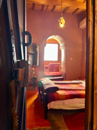 a room with two beds and a window at La Fibule D'or in Aït Ben Haddou