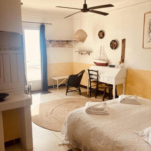 a bedroom with a bed and a desk and a table at Hôtel Lido Beach in Hyères