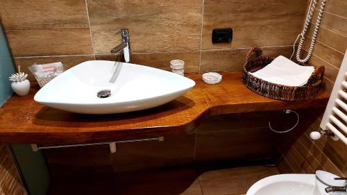 a white sink on a wooden counter in a bathroom at Attico Barocco in Lecce