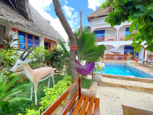 a house with a deer statue next to a pool at Utulivu Bungalow in Nungwi