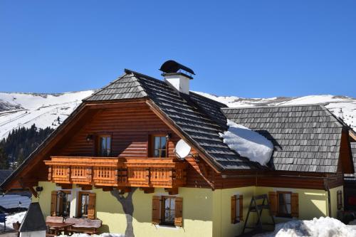 a log cabin with a balcony and snow on the ground at Lachtalhütte in Lachtal