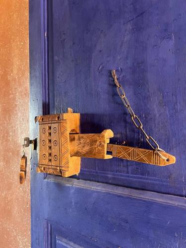 a wooden object attached to a door with a chain at La Fibule D'or in Aït Ben Haddou