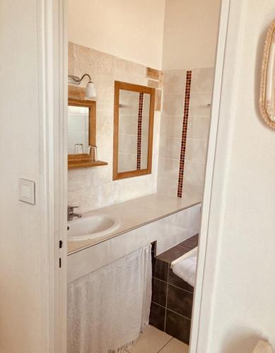 a white bathroom with a sink and a mirror at Hôtel Lido Beach in Hyères