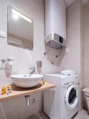 a bathroom with a sink and a washing machine at Royal Montesun Apartments in Budva