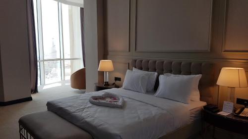 a bedroom with a bed with a tray of food on it at Horizon Manor Hotel in Doha