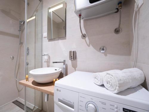 a white bathroom with a sink and a shower at Royal Montesun Apartments in Budva