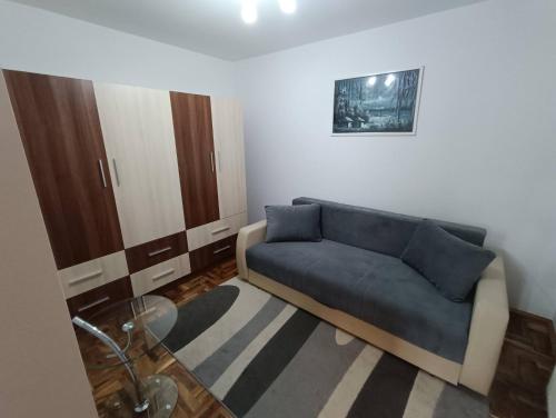 a living room with a blue couch and a rug at Fortress apartments Niš in Niš