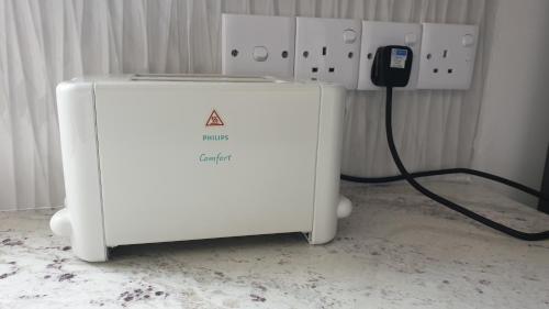 a white refrigerator with a phone plugged into it at Rodrigo Apartments 3 in Boralesgamuwa
