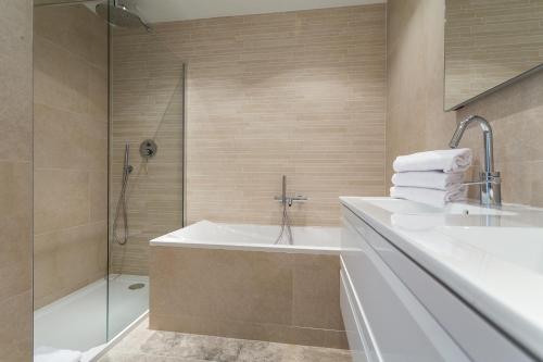 a bathroom with a tub and a sink and a shower at Villa Velvet in Villeneuve-Loubet