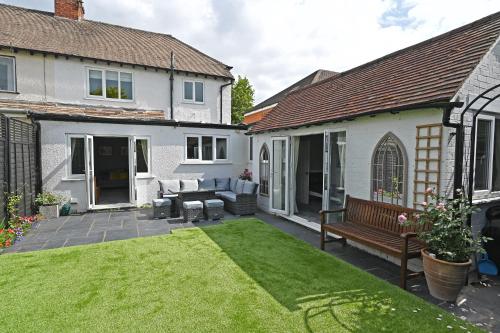a yard with a bench and a house at Central Townhouse with FREE onsite EV parking in Stratford-upon-Avon