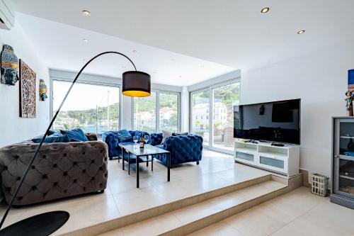 a living room with a couch and a tv at Suartini Apartmani Račišće in Račišće
