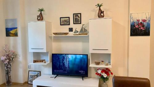 索佐波尔Sozopol Dreams apartman 35的一间带电视和白色架子的客厅