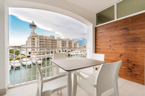 a balcony with a table and chairs and a view of a harbor at Apartamento WELCS EMP 004 con inmejorables vistas in Empuriabrava