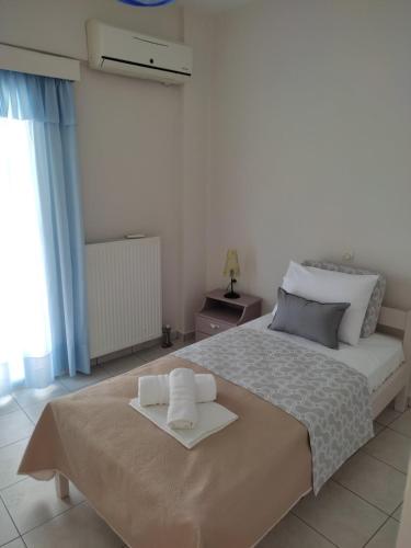 a bedroom with a bed with two towels on it at ARETI4 in Petalidi