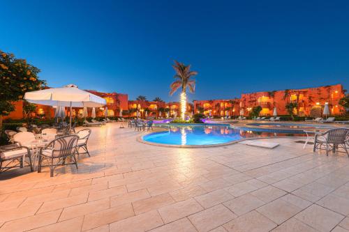 une terrasse avec des tables et des chaises ainsi qu'une piscine dans l'établissement SOULOTEL EMERALD Resort & Spa, à Marsa Alam