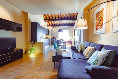 un soggiorno con divano blu e TV di HEART OF SPOLETO Vacation Residence a Spoleto