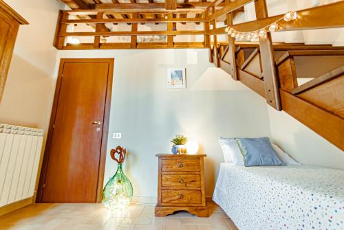 a bedroom with a bed and a wooden staircase at HEART OF SPOLETO Vacation Residence in Spoleto