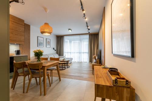 una sala da pranzo e un soggiorno con tavolo e sedie. di WILANESKA Apartament Olimpijska Szczyrk a Szczyrk