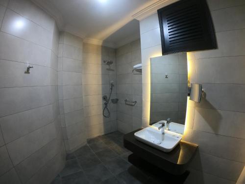 un bagno con lavandino e doccia di Horizon Manor Hotel a Doha