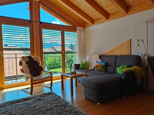 a living room with a couch and a chair at Ferienwohnung Alpenlodge in Rieden am Forggensee