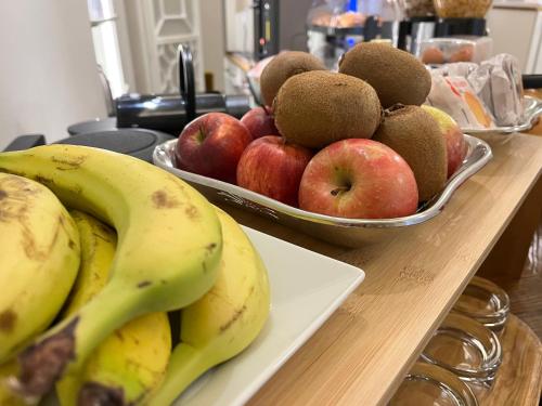 Zwei Schüsseln mit Obst auf einer Küchentheke, mit Bananen und Äpfeln. in der Unterkunft Corte dei Sogni Boutique Hotel & spa in Florenz